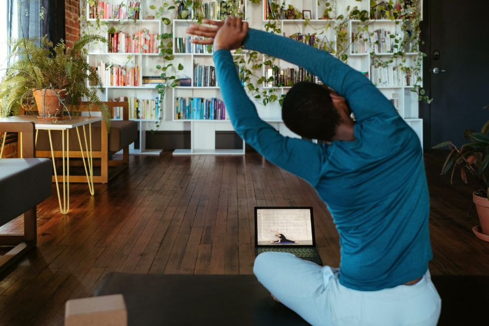 Woman doing a Yoga session in front of her laptop at home