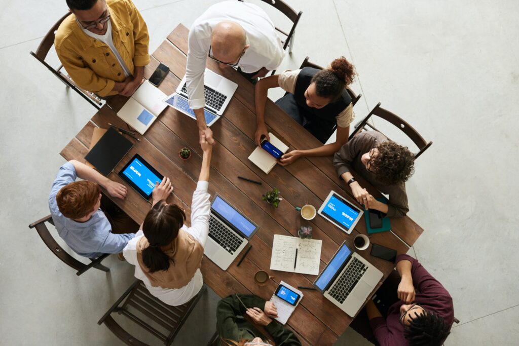 Team sitting around a table, aerial view.